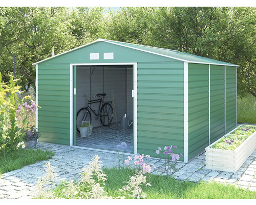 Zelený kovový zahradní domek se sedlovou střechou a posuvnými dveřmi na zahradě, uvnitř s uloženým jízdním kolem a nářadím.