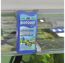 Přípravek na úpravu vody JBL Biotopol pro sladkovodní akvária na skleněném okraji akvária.