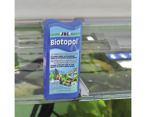 Přípravek na úpravu vody JBL Biotopol pro sladkovodní akvária na skleněném okraji akvária.