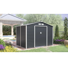 Moderní kovový zahradní domek v antracitové barvě s bílým rámem, sedlovou střechou a dvoukřídlými dveřmi v zahradě na dřevěné terase.