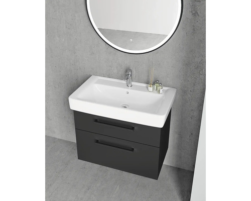 Moderní skříňka pod umyvadlo v antracitové barvě se dvěma zásuvkami a bílým umyvadlem před šedou betonovou stěnou.