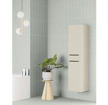 Moderní béžová nástěnná koupelnová skříňka s černými úchyty ve světle zeleně obložené koupelně s pokojovou rostlinou a kulatým svítidlem.