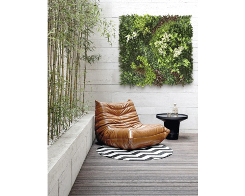 Scéna s křeslem, stolem, kulatým kobercem a zeleným nástěnným panelem na terase