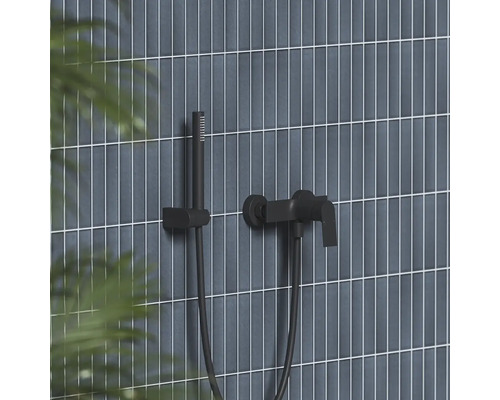 Černá nástěnná vanová baterie s ruční sprchou a držákem na stěně s vertikálními obklady.