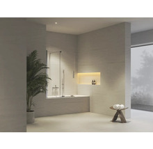 Moderní světlá koupelna s vanou, dvoudílnou skleněnou vanovou zástěnou, osvětleným výklenkem ve stěně a pokojovou rostlinou.