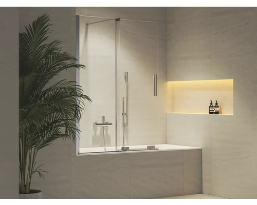 Moderní vanová zástěna ze skla s kovovým kováním ve světlé koupelně s nástěnným výklenkem a pokojovou rostlinou.