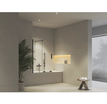 Moderní světlá koupelna se skleněnou sprchovou zástěnou na vaně, armaturami, pokojovou rostlinou a osvětleným výklenkem.