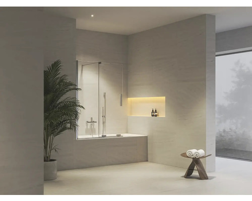 Moderní světlá koupelna s vanou, skleněnou sprchovou zástěnou, osvětleným výklenkem ve stěně a velkoformátovými obklady.