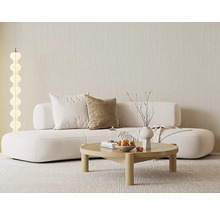 Světlý obývací pokoj s moderní bílou pohovkou, kulatým dřevěným stolem, pruhovaným kobercem a stojací lampou se svítícími koulemi u strukturované zdi.