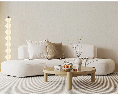 Světlý obývací pokoj s moderní bílou pohovkou, kulatým dřevěným stolem, pruhovaným kobercem a stojací lampou se svítícími koulemi u strukturované zdi.