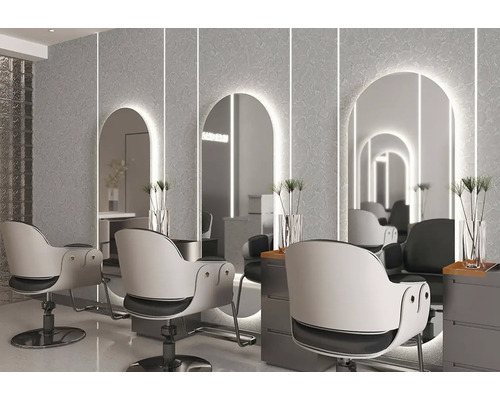 Moderní kadeřnictví se třemi osvětlenými obloukovými zrcadly na strukturované stěně, bílými otočnými křesly a šedými odkládacími stolky.