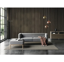 Moderní obývací pokoj s tmavým nástěnným panelem ve vzhledu dřeva, šedou polstrovanou pohovkou s taburetem, závěsnými svítidly a velkým oknem.