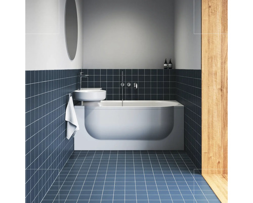Moderní světlá koupelna s bílou vanou, malým kulatým umyvadlem, modrými dlaždicemi, chromovými armaturami a dřevěným obložením.