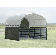 Mobilní přístřešek pro zvířata s šedou klenutou střechou a černými kovovými ohradami na louce.