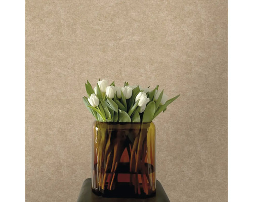 Strukturovaná vliesová tapeta v béžové barvě s jemným vzhledem omítky, před ní skleněná váza s bílými tulipány.