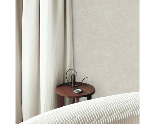 Světlá strukturovaná vliesová tapeta ve světlém obývacím pokoji s bílým závěsem a kulatým dřevěným stolkem.