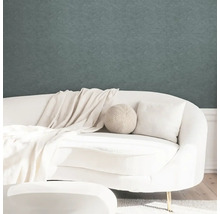 Strukturovaná tapeta v moderně zařízeném obývacím pokoji s bílou zaoblenou pohovkou a světlým textilem.