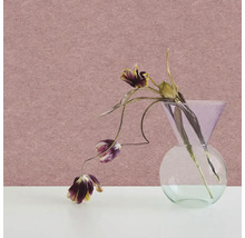 Vliesová tapeta ve starorůžové barvě s jemnou zrnitou strukturou, před ní skleněná váza se sušenými květinami.