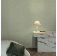 Strukturovaná zelená tapeta v moderně zařízeném pokoji s mramorovým stolem a stolní lampou.