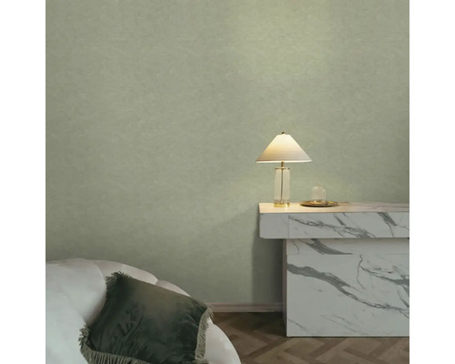 Strukturovaná zelená tapeta v moderně zařízeném pokoji s mramorovým stolem a stolní lampou.