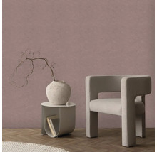 Strukturovaná vliesová tapeta ve starorůžové barvě v moderním pokoji s béžovým křeslem, kulatým stolkem a parketami.