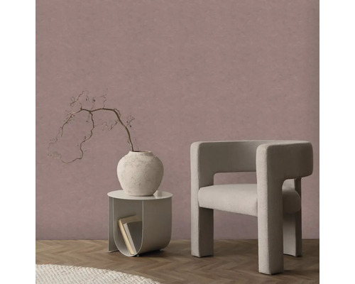 Strukturovaná vliesová tapeta ve starorůžové barvě v moderním pokoji s béžovým křeslem, kulatým stolkem a parketami.