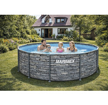 Rodina v nadzemním kruhovém bazénu Marimex s dekorem kamene na zahradě u rodinného domu.