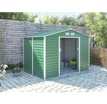 Zelený kovový zahradní domek se sedlovou střechou a posuvnými dveřmi na dlážděné terase u cihlové zdi.