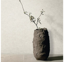 Ručně vyrobená váza s texturovaným povrchem a kvetoucí větví.