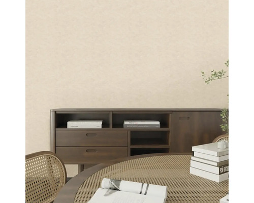 Pokoj se světlou strukturovanou tapetou, tmavým dřevěným příborníkem a stolem s ratanovým výpletem ve světlém interiéru.