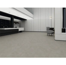 Prostorný, moderní interiér s velkoformátovou šedou podlahou, bílými obloženými stěnami a minimalistickým designem.