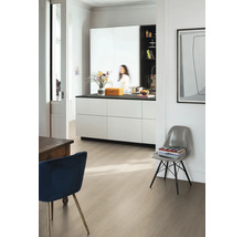 Moderní světlý pokoj s laminátovou podlahou ve světlém dekoru dřeva, bílým kuchyňským ostrůvkem s černou pracovní deskou a designovými židlemi.