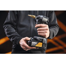 Akumulátorový rázový utahovák DeWalt Special Edition se stupňovitým vrtákem a 18 Volt akumulátorem v rukou osoby.