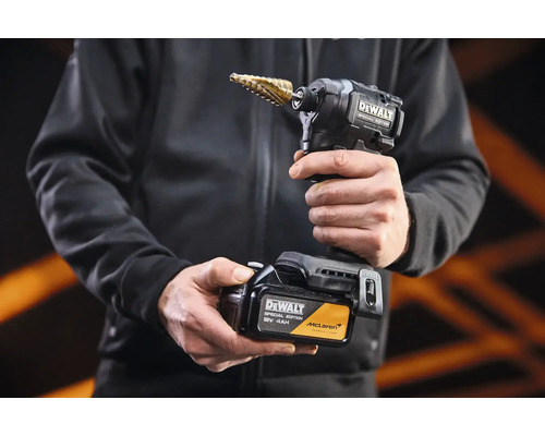 Akumulátorový rázový utahovák DeWalt Special Edition se stupňovitým vrtákem a 18 Volt akumulátorem v rukou osoby.