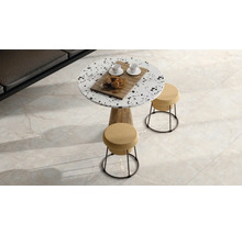 Moderní obývací pokoj s dlažbou v mramorovém vzhledu, kulatým terazzovým stolem a stoličkami s korkovým sedákem.