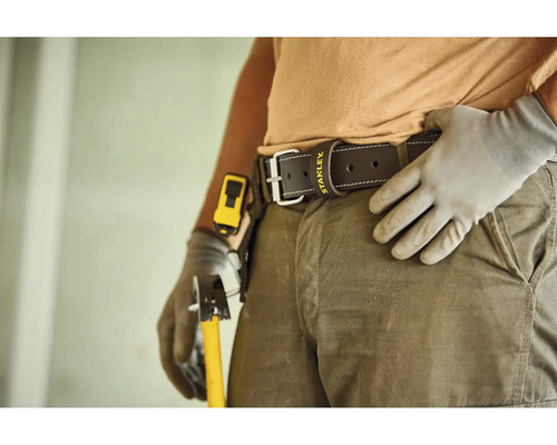 Kožený pracovní opasek s Stanley Logo na osobě v pracovním oděvu s rukavicemi a nářadím.