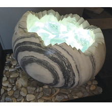 Dekorativní lampa ve tvaru rozbitého vejce z mramorovaného kamene, plněná svítícími skleněnými kameny na oblázcích.
