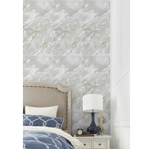 Nástěnné obklady s mramorovým efektem v ložnici za postelí a nočním stolkem s lampou.