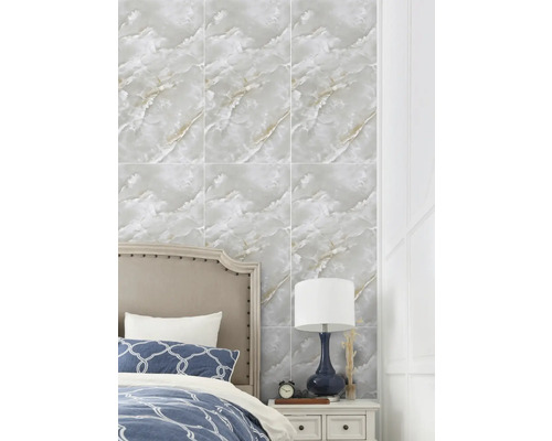 Nástěnné obklady s mramorovým efektem v ložnici za postelí a nočním stolkem s lampou.