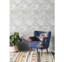 Obklad v imitaci mramoru ve světlé místnosti s modrým křeslem a pokojovou rostlinou.