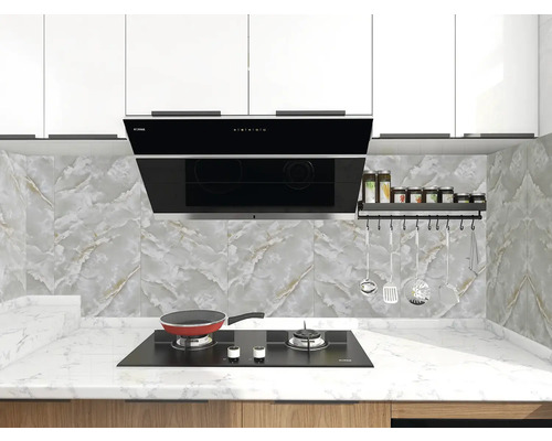 Moderní světlá kuchyně s černou digestoří, plynovou varnou deskou na bílé mramorové pracovní desce a obkladem v dekoru mramoru s náčiním.