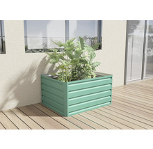 Kovový vyvýšený záhon s rostlinami na dřevěné terase u stěny domu.