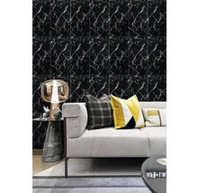 Nástěnná dekorace ve vzhledu černého mramoru s bílými žilkami za šedou pohovkou s dekoračními polštáři a moderní stolní lampou.