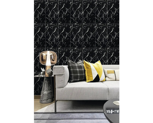 Nástěnná dekorace ve vzhledu černého mramoru s bílými žilkami za šedou pohovkou s dekoračními polštáři a moderní stolní lampou.