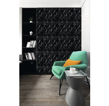 Černé nástěnné panely se vzhledem mramoru v moderně zařízeném obývacím pokoji se zeleným křeslem a dřevěnou podlahou.