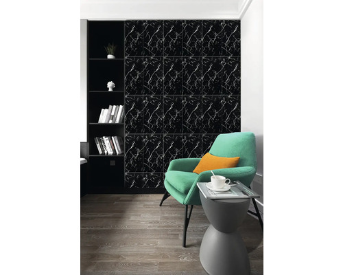 Černé nástěnné panely se vzhledem mramoru v moderně zařízeném obývacím pokoji se zeleným křeslem a dřevěnou podlahou.
