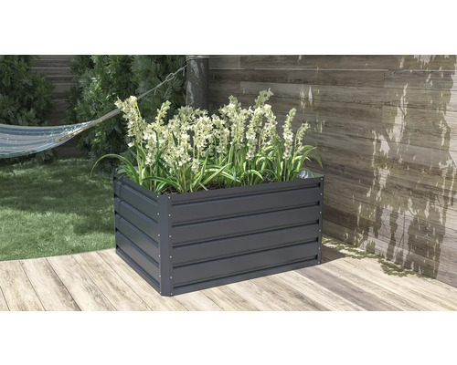 Obdélníkový kovový vyvýšený záhon v antracitové barvě s bílými květinami na dřevěné terase.