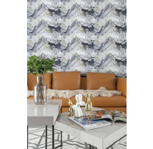 Moderní nástěnný obklad v mramorovém vzhledu za koženou pohovkou a konferenčním stolkem s dekorací ve světlém obývacím pokoji.