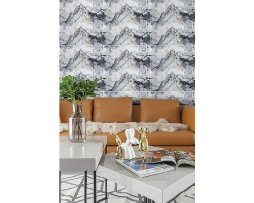 Moderní nástěnný obklad v mramorovém vzhledu za koženou pohovkou a konferenčním stolkem s dekorací ve světlém obývacím pokoji.