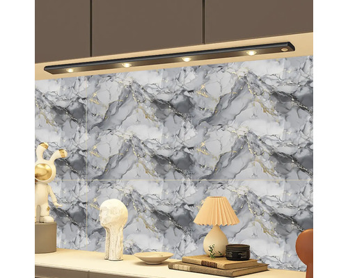 Mramorovaná nástěnná dekorace v šedé a bílé s černým LED osvětlením pod skříňkou nad odkládací plochou s dekoracemi a lampičkou.